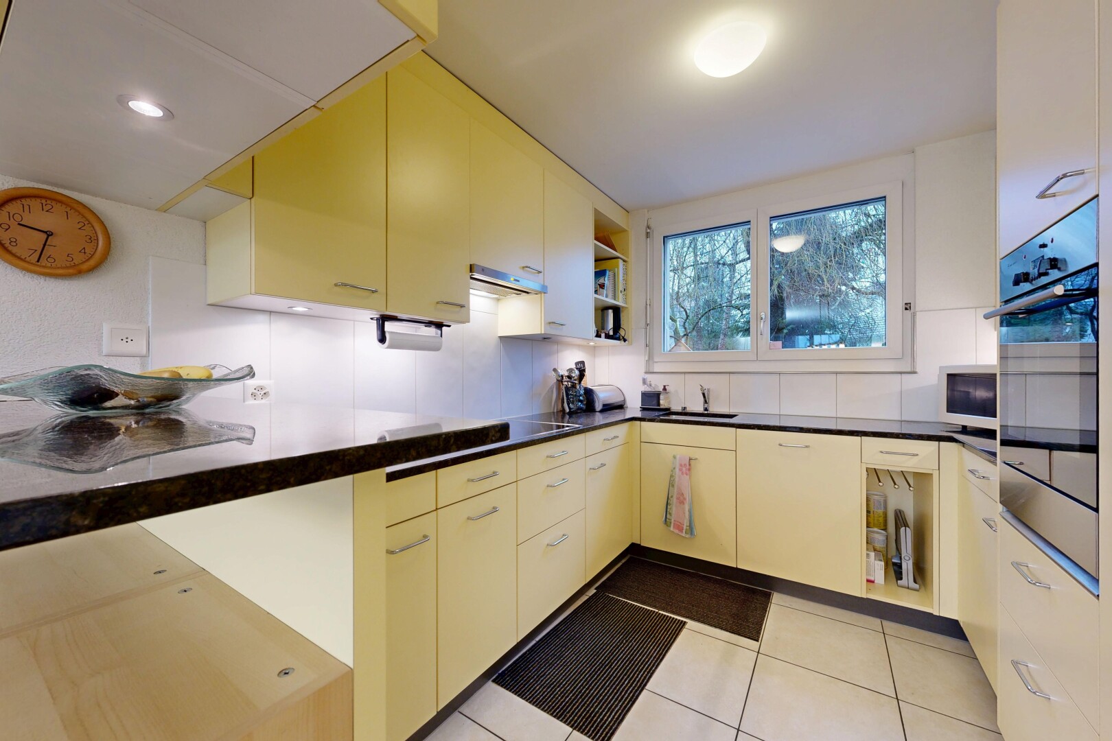 cuisine avec plans de travail, dark countertops, four, étagères ouvertes, et open shelves