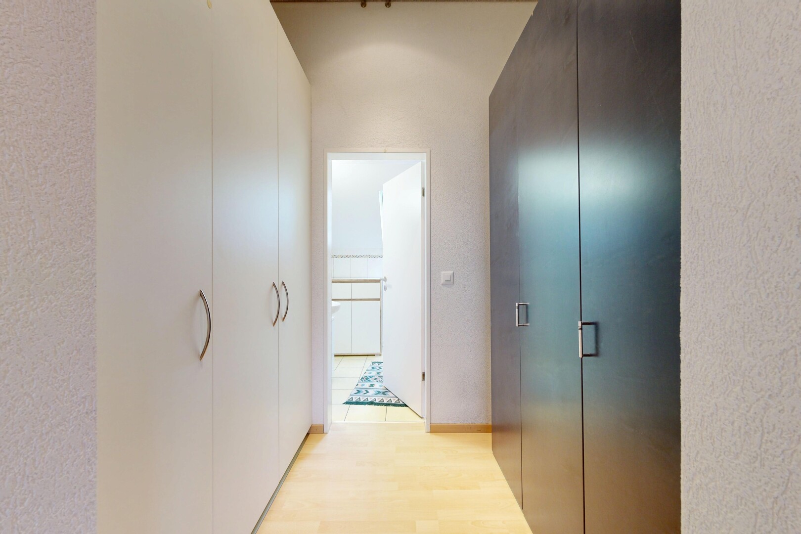 couloir avec sol en finition bois, wood finish floor, inside property, et light floor