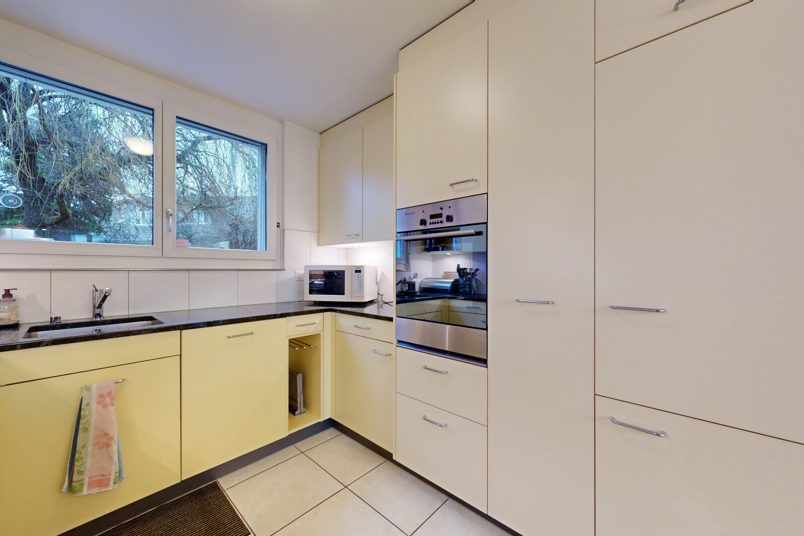 cuisine avec four, plans de travail, dark countertops, light floor, et tile floor