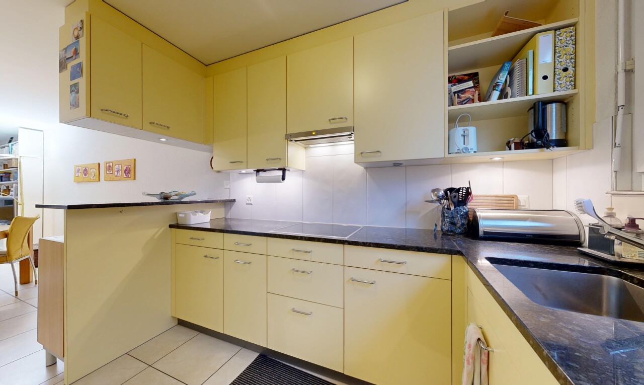 cuisine avec dark countertops, péninsule de cuisine, kitchen peninsula, évier, et tile floor