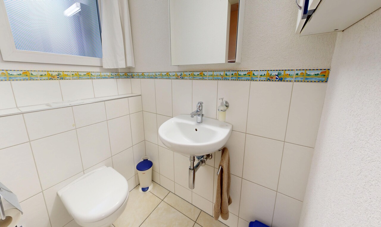 salle de bains avec toilette, mur en carrelage, tile wall, miroir, et inside property