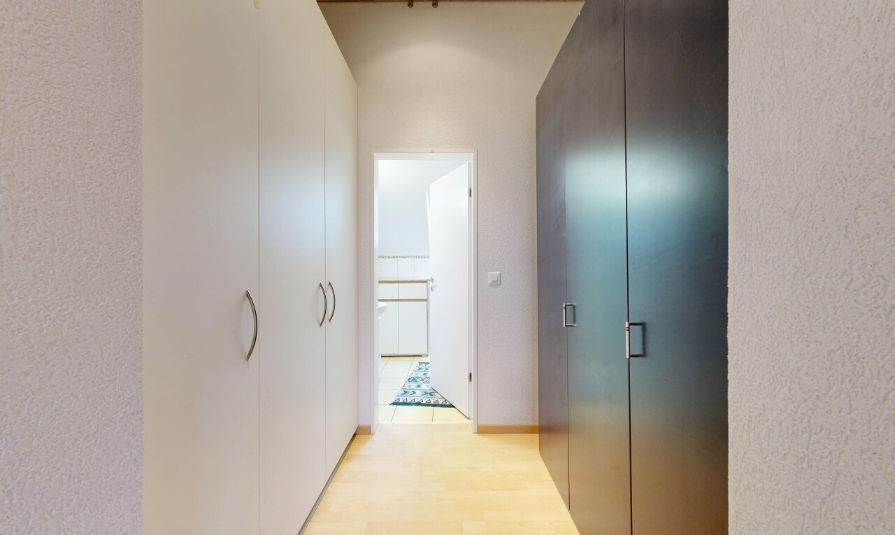 couloir avec sol en finition bois, wood finish floor, inside property, et light floor