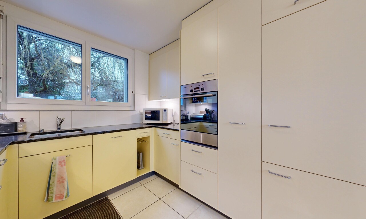 cuisine avec four, plans de travail, dark countertops, light floor, et tile floor