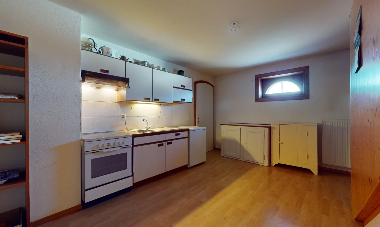 cuisine avec radiateur, plancher de bois, plan de travail, hotte, et four intégré