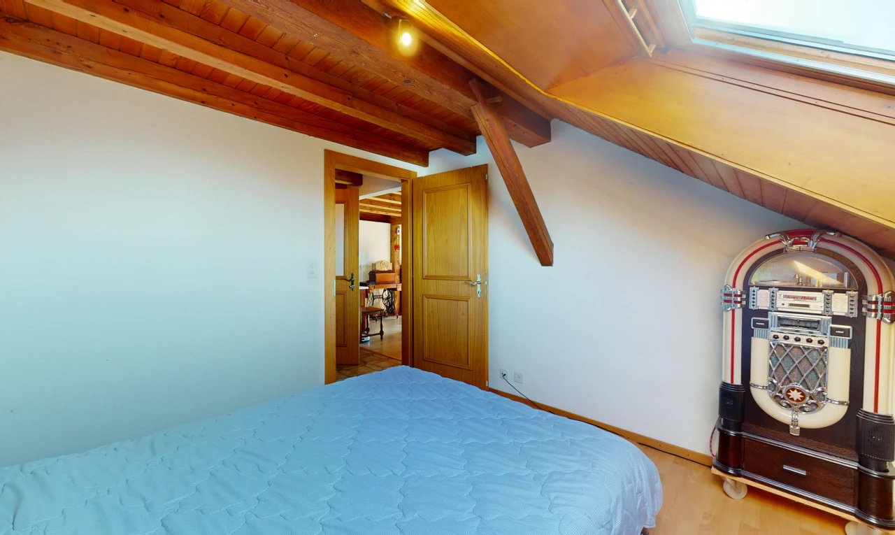 chambre avec plafond de bois, poutres apparentes, et plancher de bois