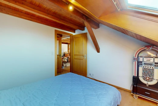 chambre avec plafond de bois, poutres apparentes, et plancher de bois