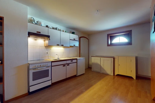 cuisine avec radiateur, plancher de bois, plan de travail, hotte, et four intégré