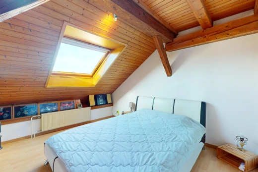 chambre avec radiateur, plafond de bois, plafond voûté, lucarne, et plancher de bois