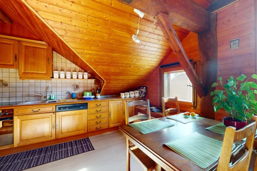 cuisine avec mur en bois, crédence, lumière naturelle, et plafond voûté