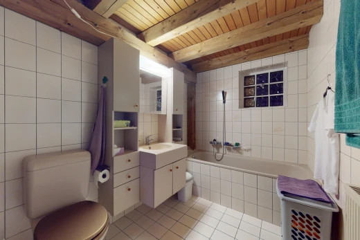 salle de bains avec mur carrelé, vasque, poutres apparentes, carrelage, et baignoire