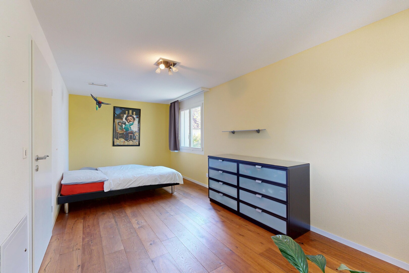 zimmer / schlafzimmer mit natürliches licht, drywall, gipskartonwand, wood finish floor, und holzfußboden