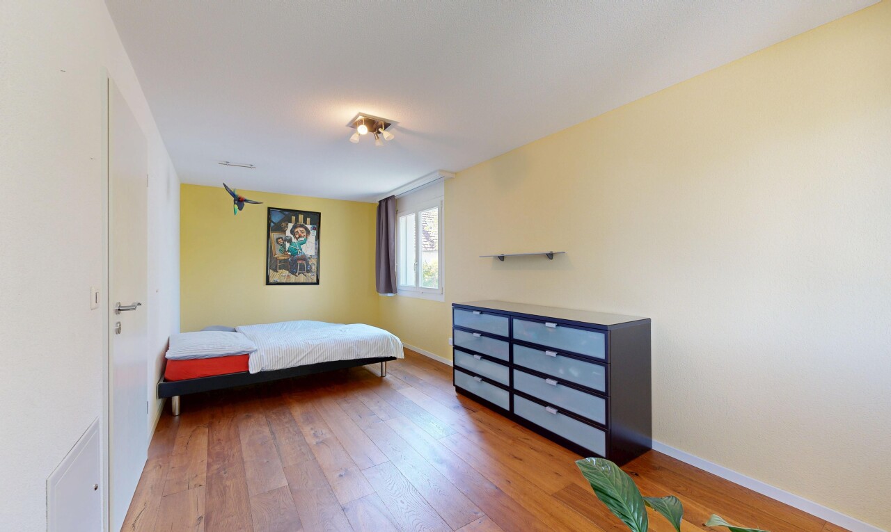 zimmer / schlafzimmer mit natürliches licht, drywall, gipskartonwand, wood finish floor, und holzfußboden