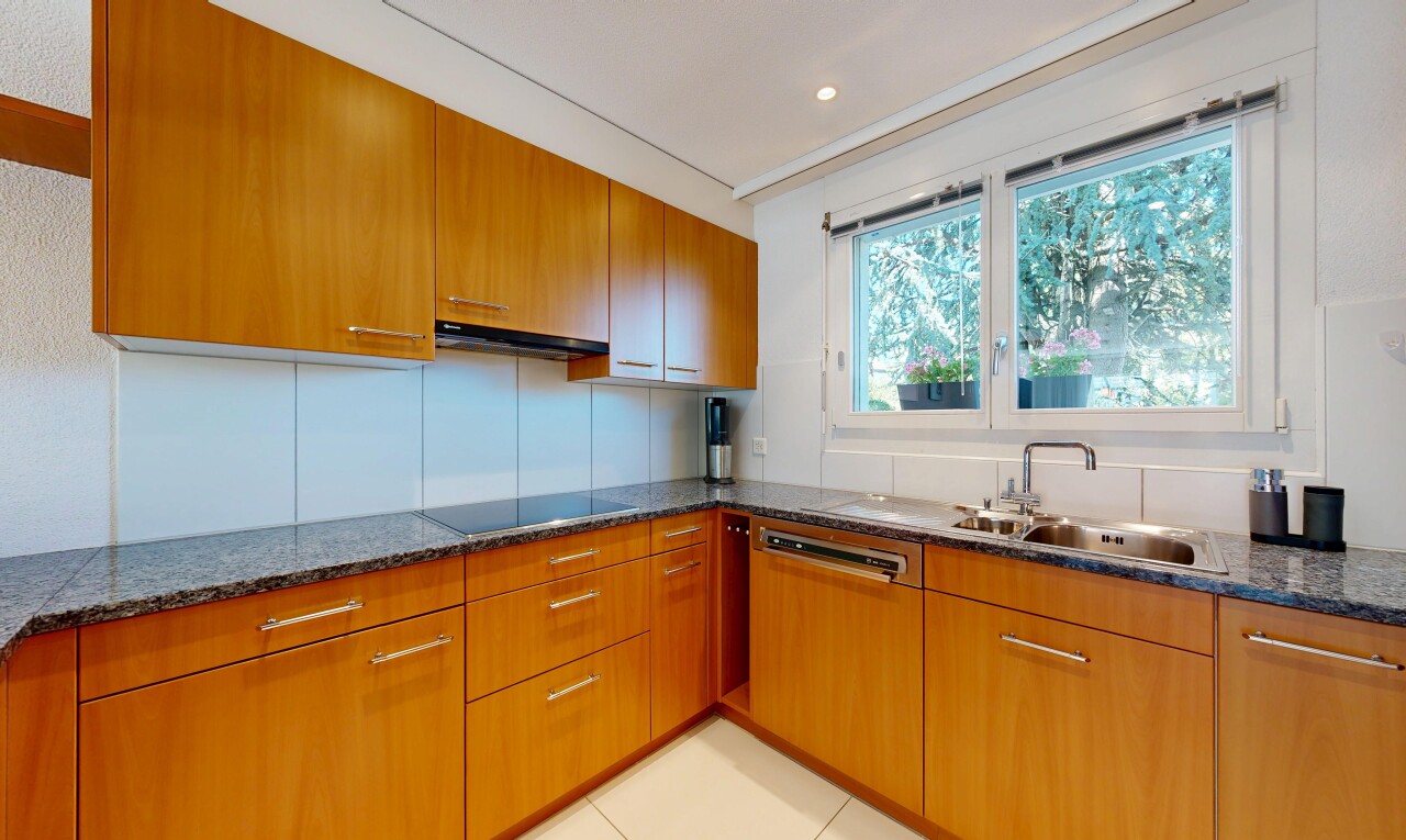 küche mit dark countertops, light floor, waschbecken, medium brown cabinets, und mittelbraune schränke