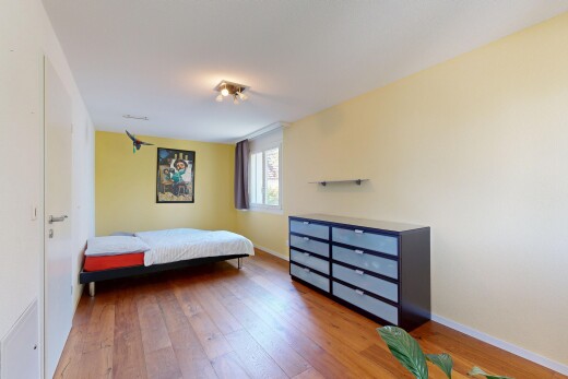 zimmer / schlafzimmer mit natürliches licht, drywall, gipskartonwand, wood finish floor, und holzfußboden