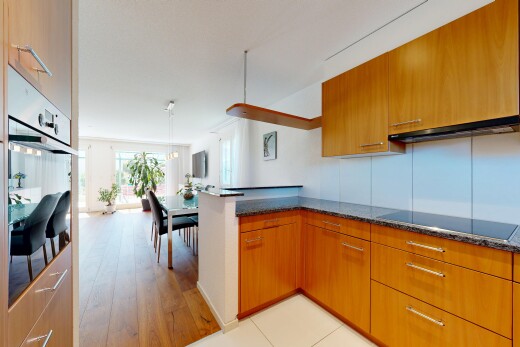 küche mit dark countertops, medium brown cabinets, mittelbraune schränke, light floor, und kitchen peninsula