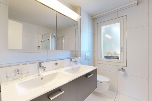 full bath featuring a stall shower, tile walls, double vanity, and light tile patterned flooring