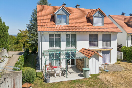 façade avec toit mansardé, toit en tuiles, cheminée, terrasse, et property visible
