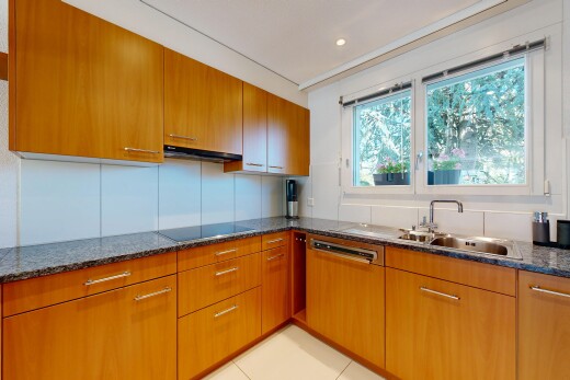 kitchen with wood finish cabinetry, dark stone counters, and recessed lighting