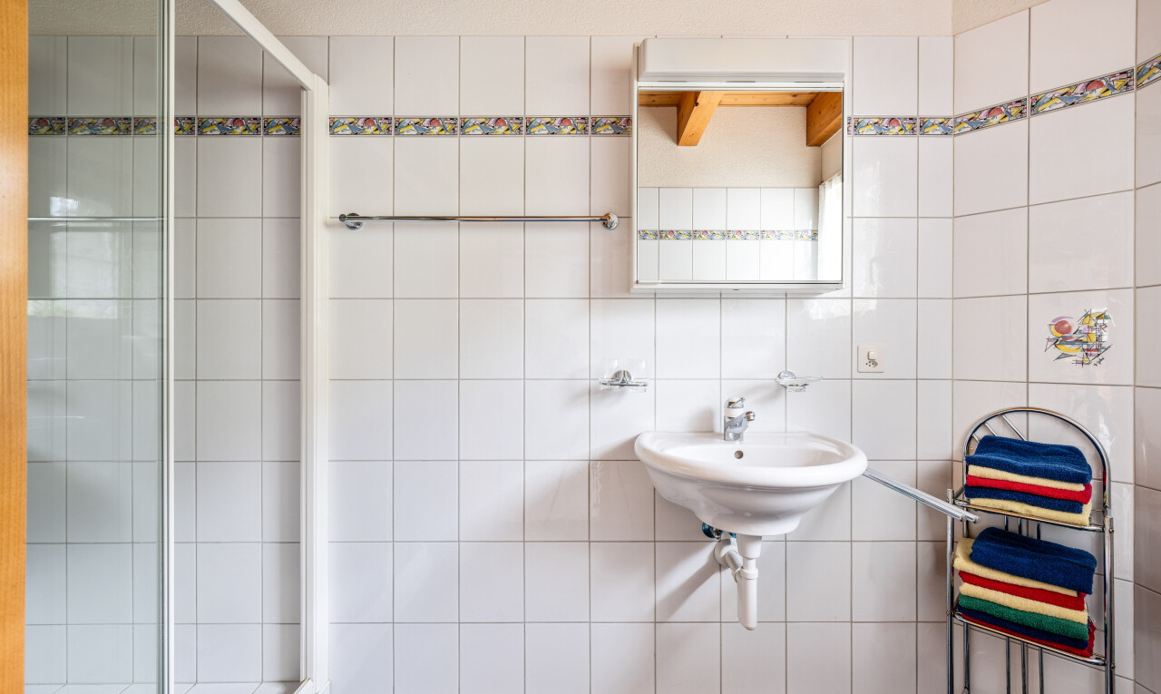 bad mit dusche, spiegel, komplettes badezimmer, waschbecken, und fliesenwand