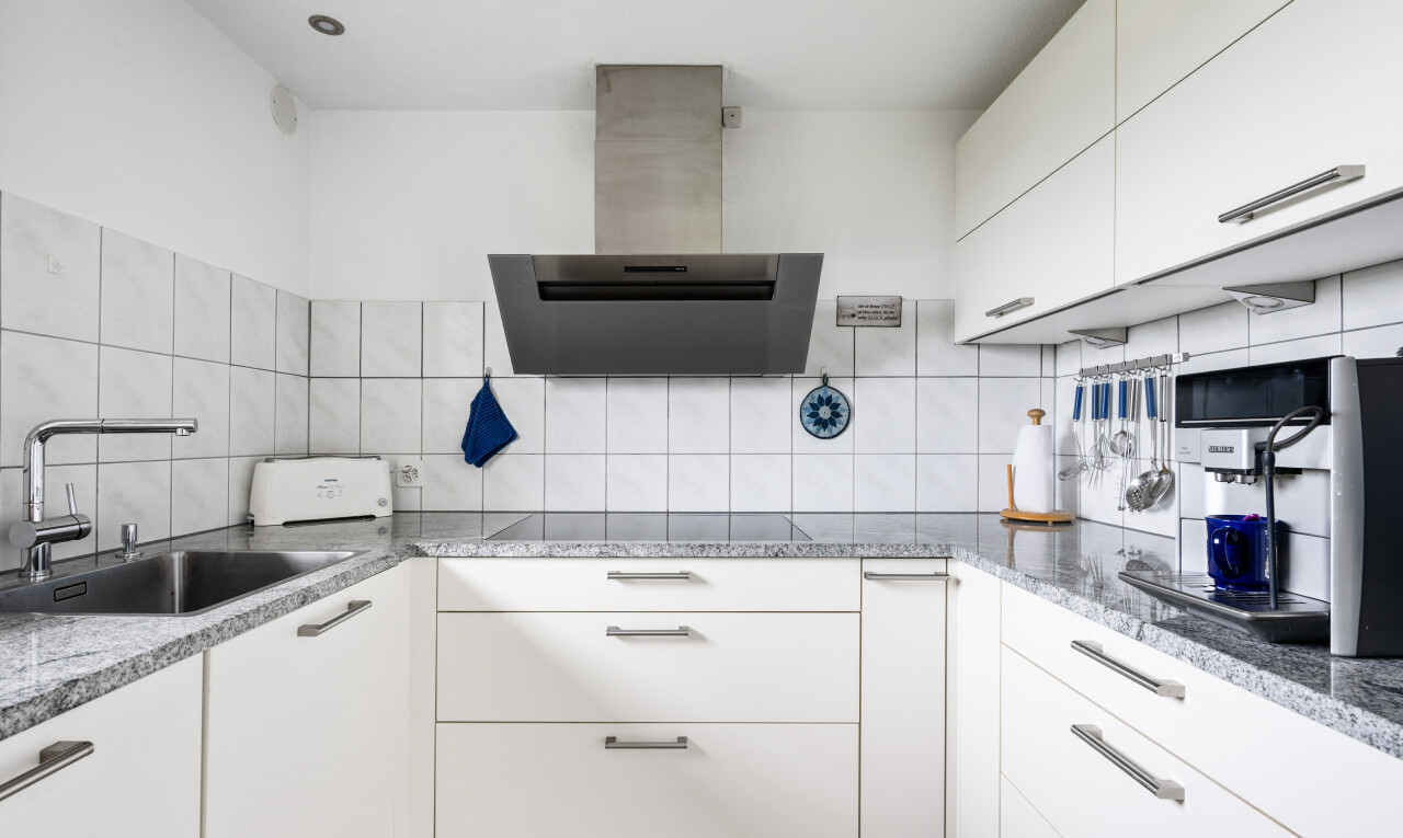küche mit dunstabzugshaube, weiße schränke, white cabinets, stein arbeitsplatten, und stone countertops