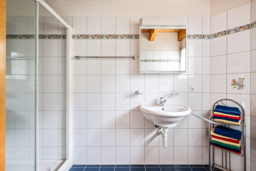 bad mit dusche, spiegel, komplettes badezimmer, waschbecken, und fliesenwand