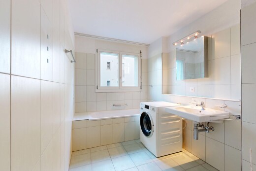 salle de bains avec tile wall, mur en carrelage, bain, lave-linge et sèche-linge, et salle de bain complète