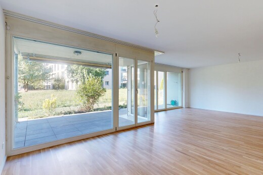 pièce vide avec drywall, cloison sèche, accès à l'extérieur, wood finish floor, et sol en finition bois