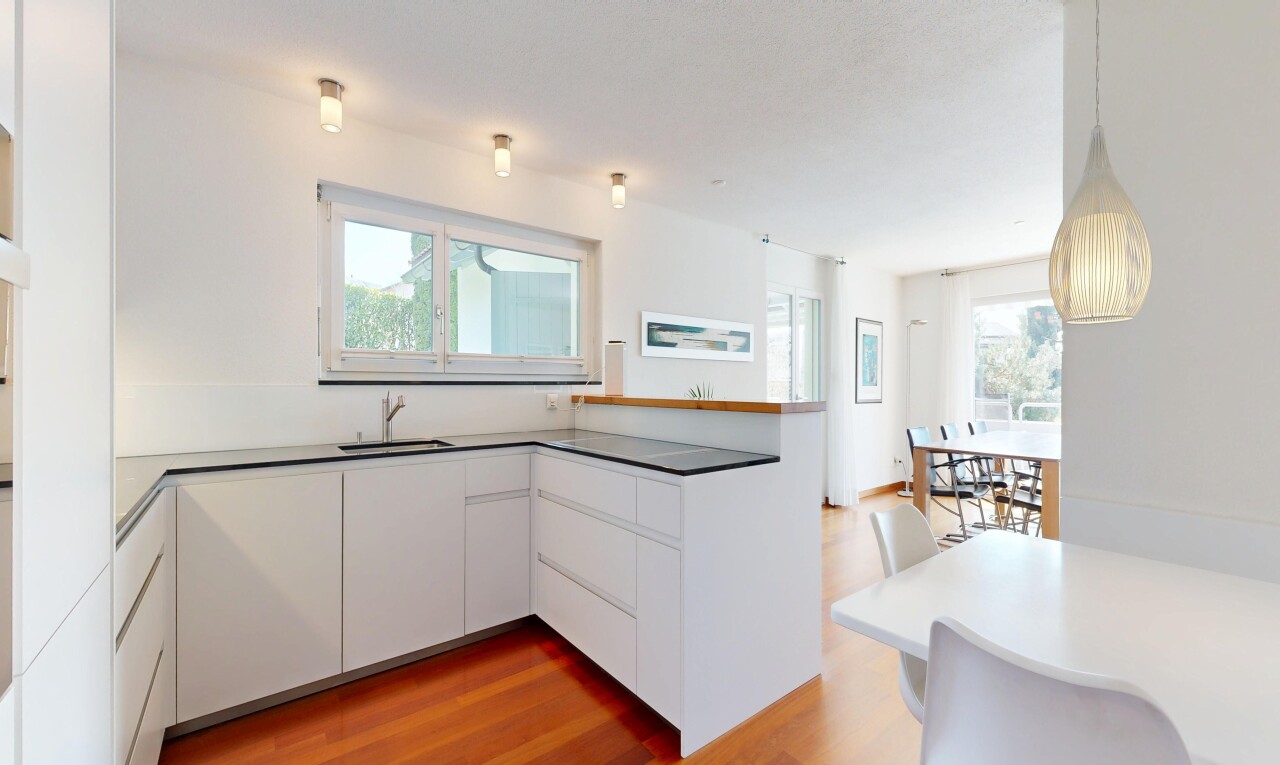 cuisine avec two heights countertops, armoires blanches, white cabinets, sol en finition bois, et wood finish floor