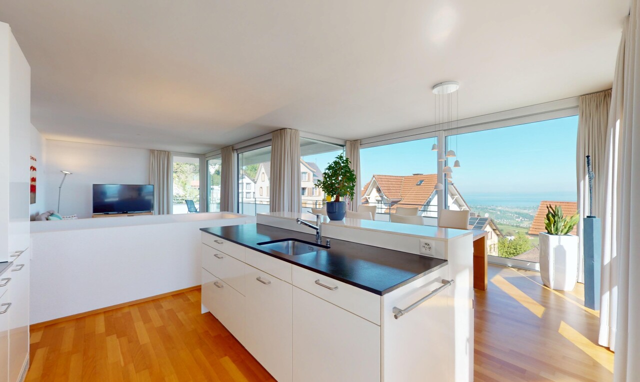 kitchen with a sink, dark countertops, light wood-style flooring, and open floor plan
