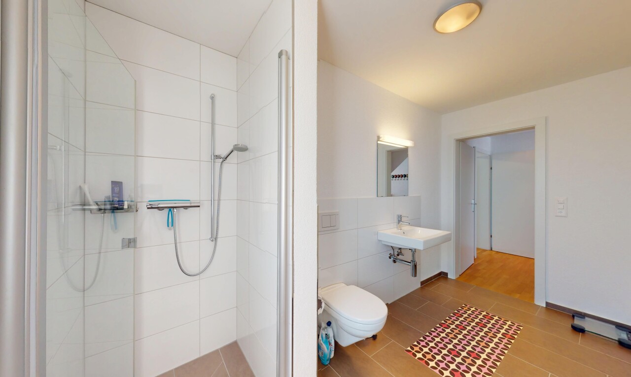 full bath with tile walls, a tile shower, toilet, and wood finished floors