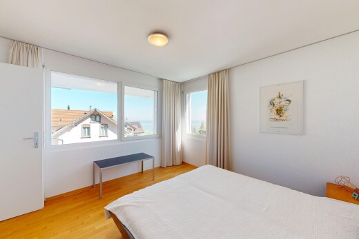 zimmer / schlafzimmer mit natürliches licht, holzfußboden, und gipskartonwand