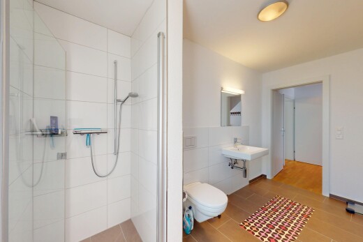 full bath with tile walls, a tile shower, toilet, and wood finished floors