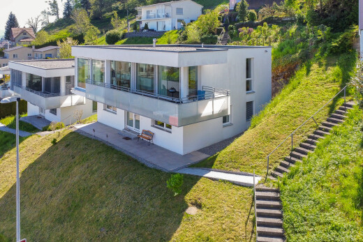 äußeresraum mit balkon, terrasse, glasverkleidung, rasen, und treppen