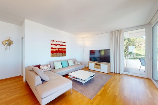 wohnzimmer mit gipskartonwand, holzfußboden, fernseher, und natürliches licht