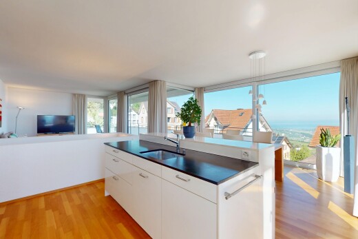 kitchen with a sink, dark countertops, light wood-style flooring, and open floor plan