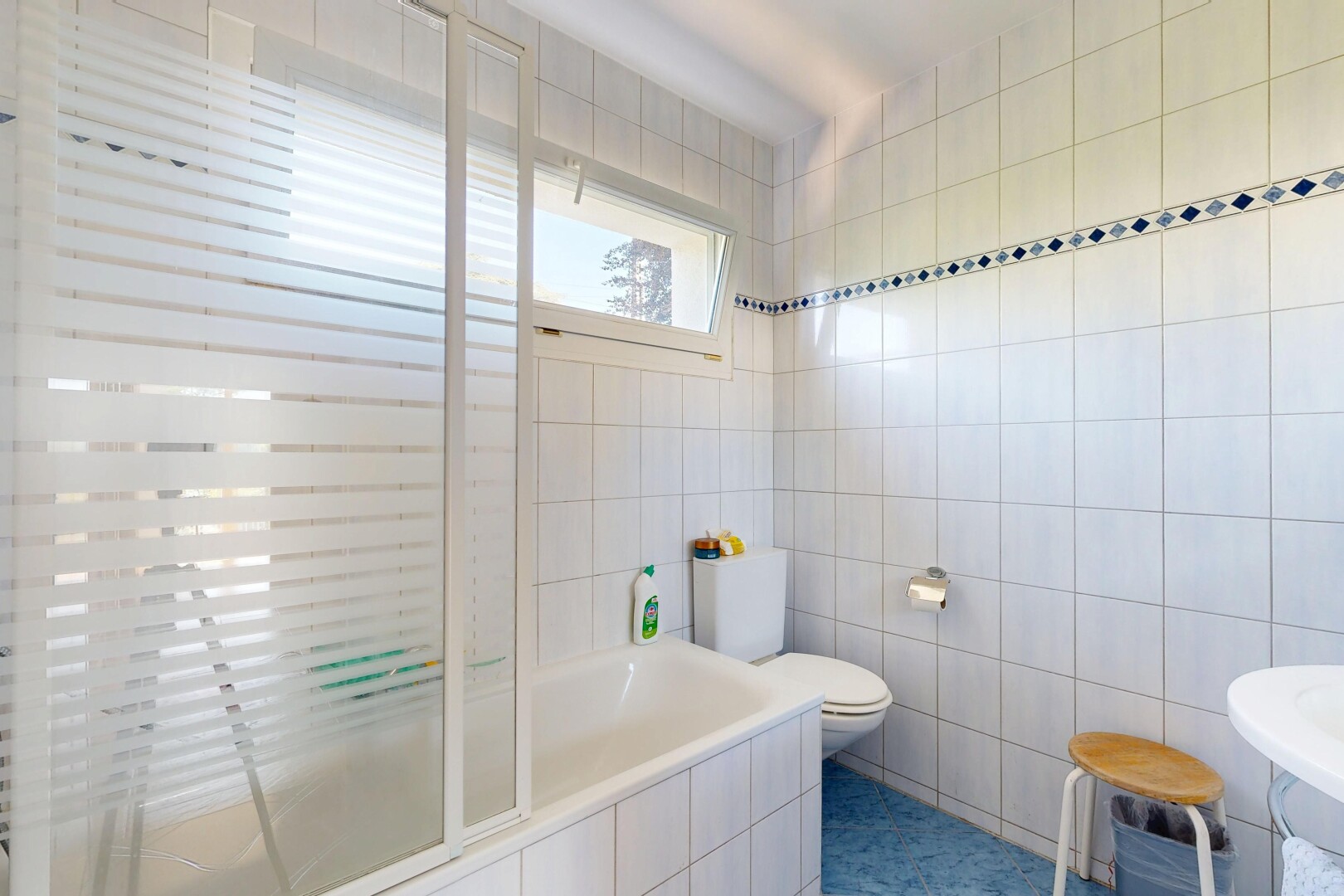 salle de bains avec mur en carrelage, tile wall, inside property, salle de bain complète, et lumière naturelle