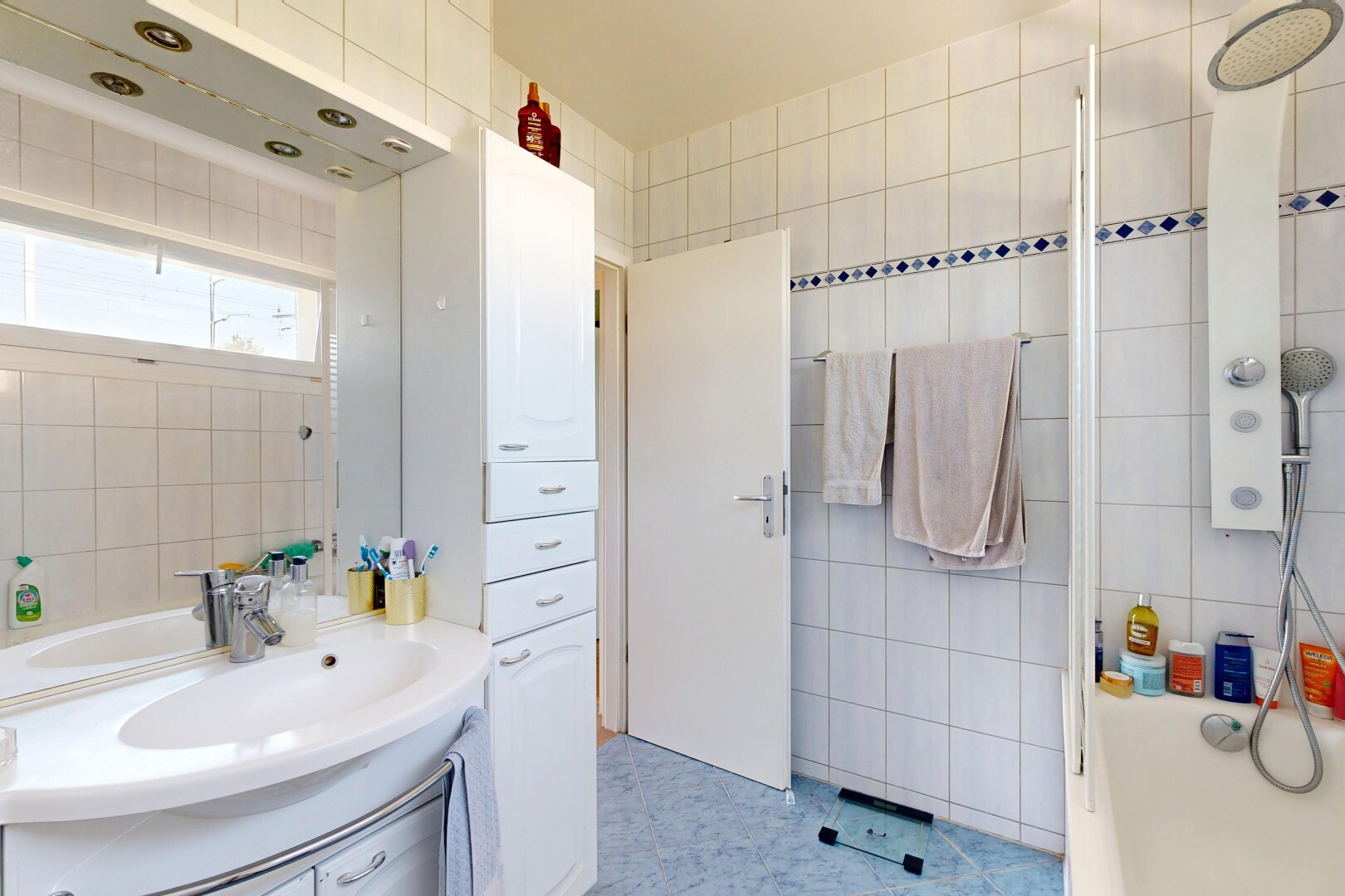 salle de bains avec mur en carrelage, tile wall, lavabo (ou coiffeuse selon le contexte), inside property, et salle de bain complète