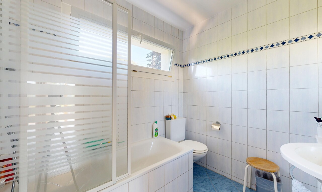 salle de bains avec mur en carrelage, tile wall, inside property, salle de bain complète, et lumière naturelle