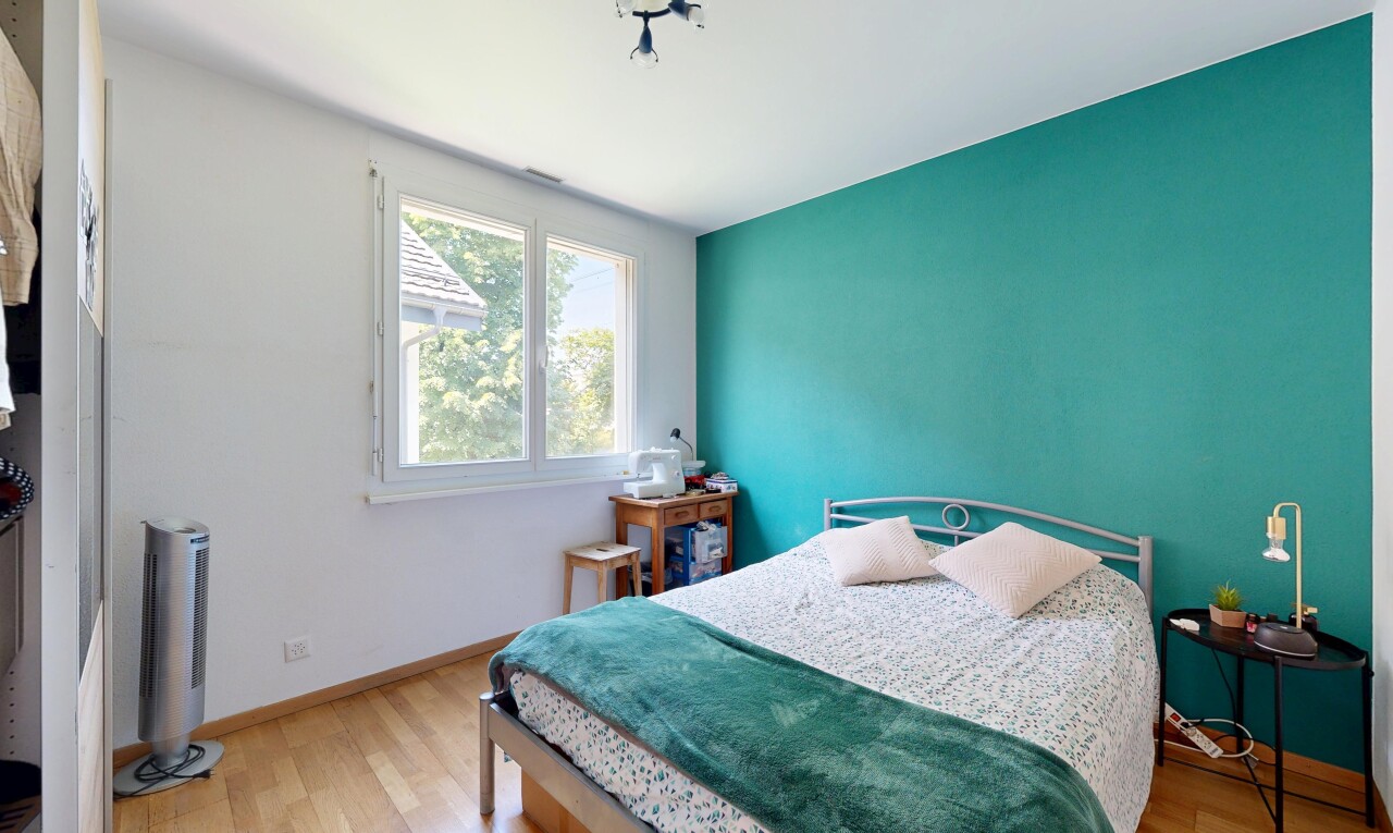 chambre avec cloison sèche, drywall, sol en finition bois, wood finish floor, et lumière naturelle