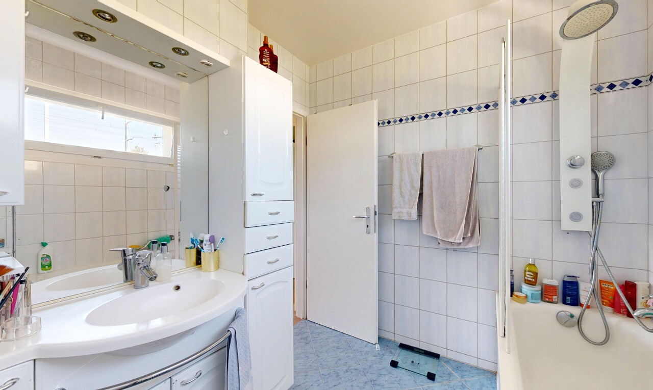 salle de bains avec mur en carrelage, tile wall, lavabo (ou coiffeuse selon le contexte), inside property, et salle de bain complète