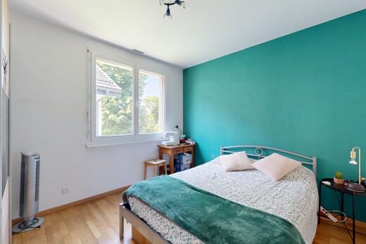 chambre avec cloison sèche, drywall, sol en finition bois, wood finish floor, et lumière naturelle