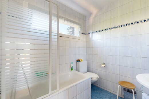 salle de bains avec mur en carrelage, tile wall, inside property, salle de bain complète, et lumière naturelle