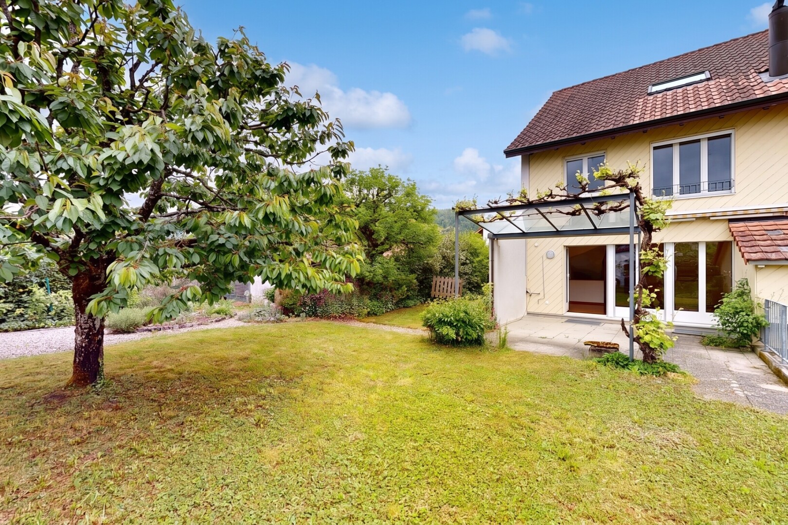 view of home featuring a yard, a patio, and a shingled roof