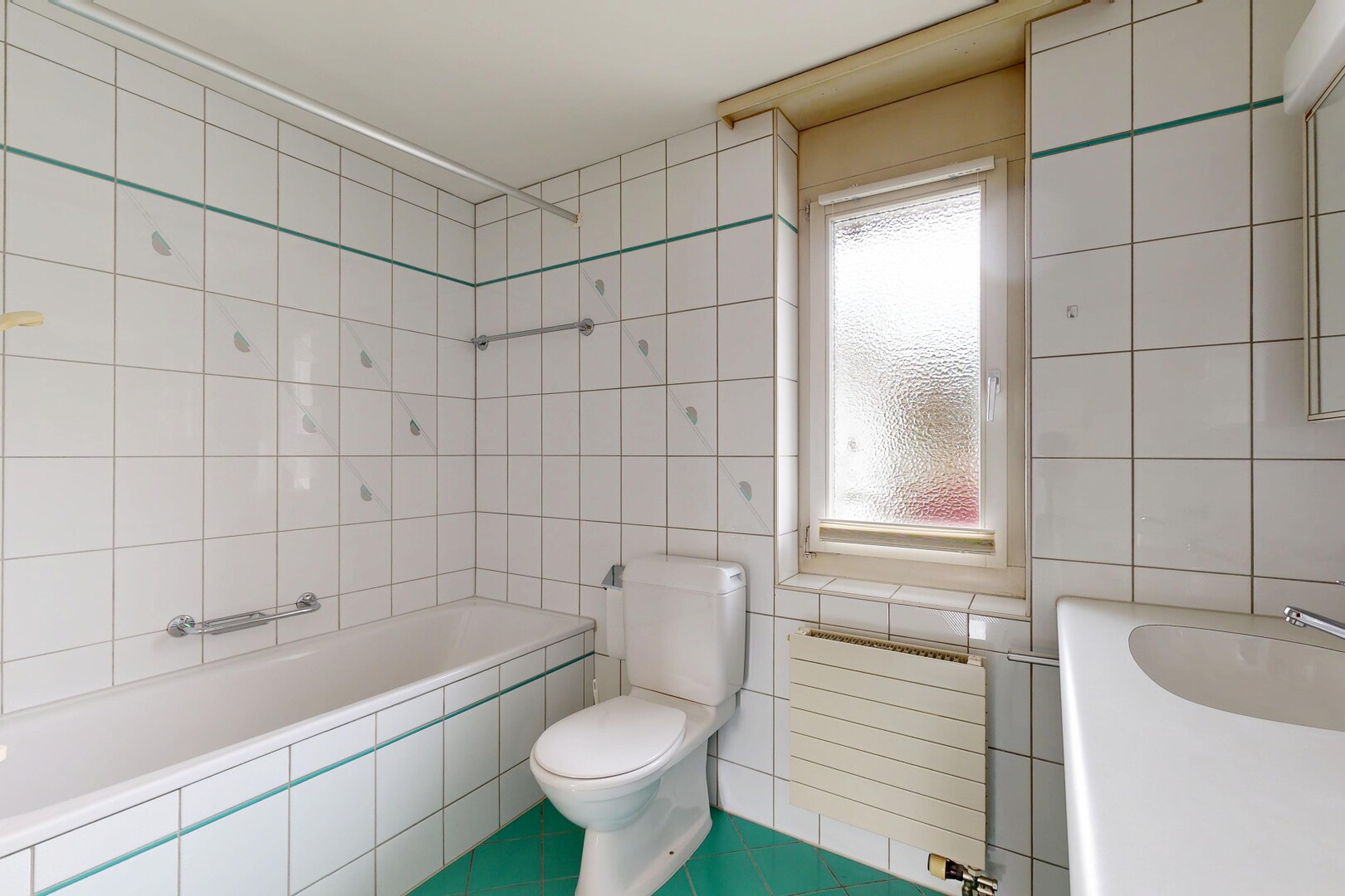 bathroom featuring tiled bath, radiator heating unit, tile walls, tile patterned flooring, and vanity