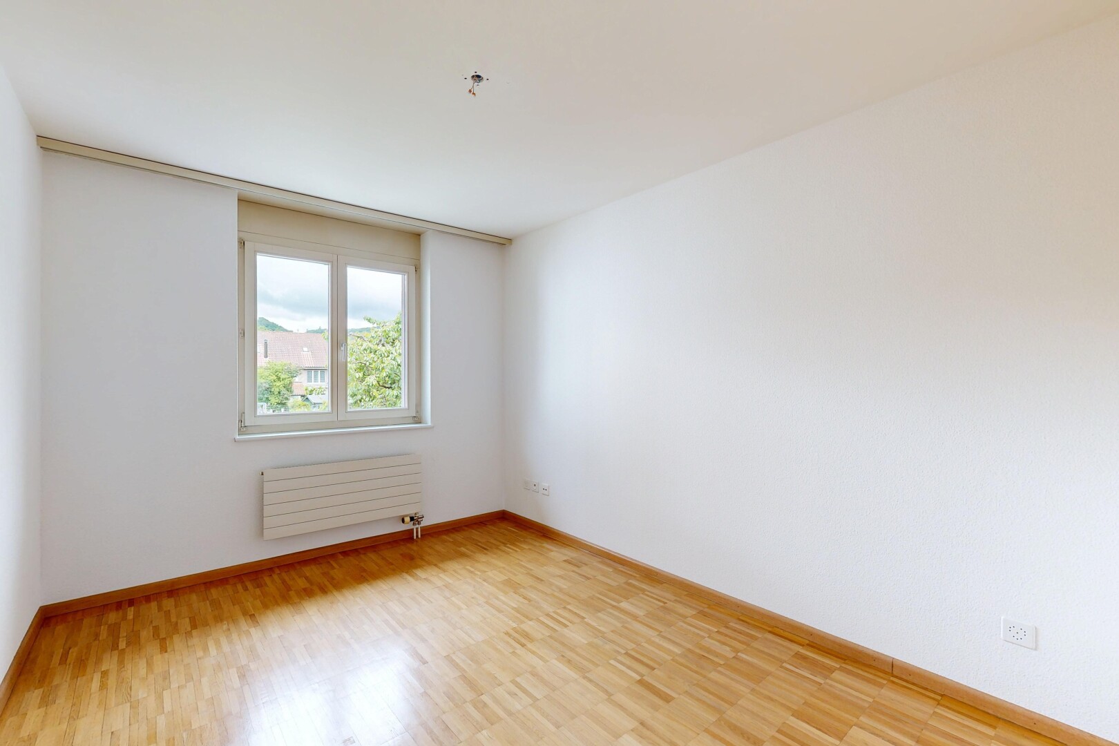spare room with light wood-type flooring and radiator