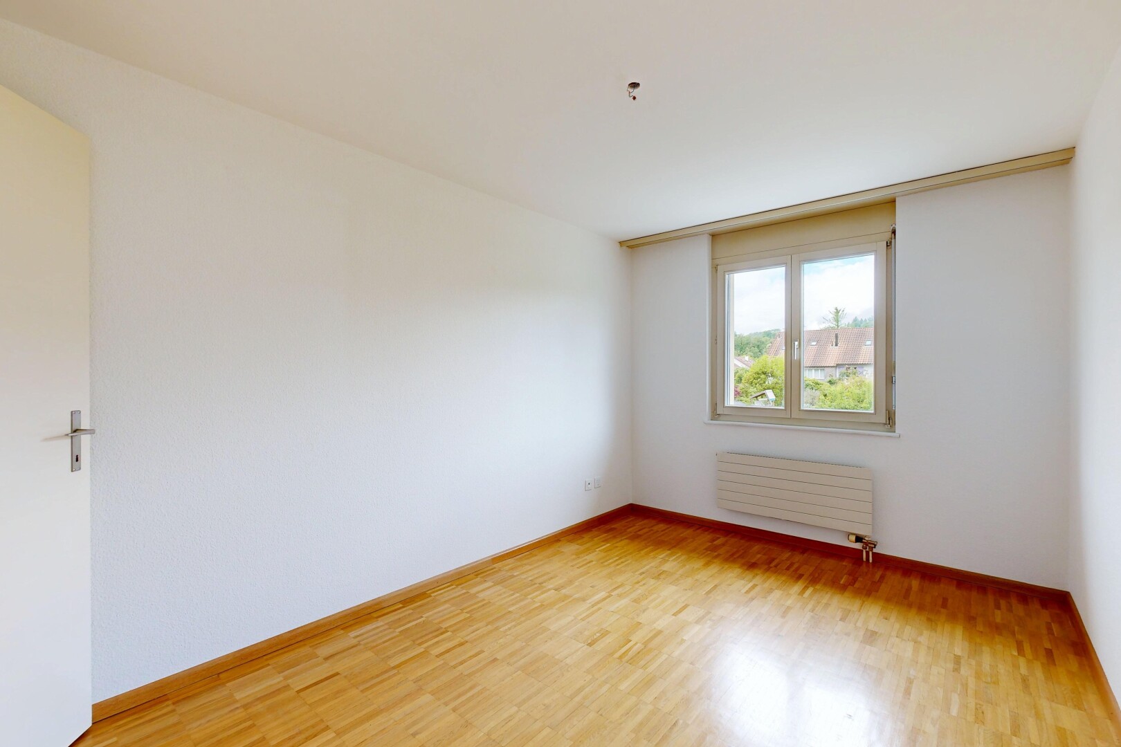 empty room with light wood-type flooring and radiator heating unit