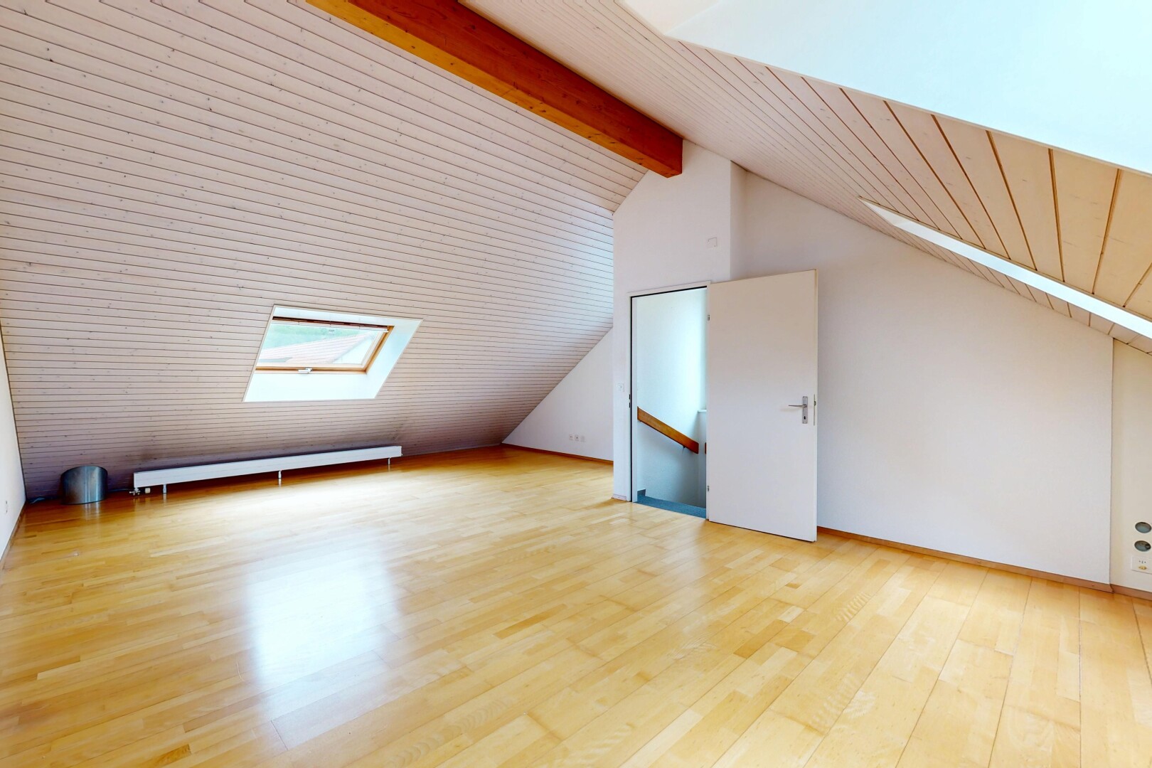 spare room featuring a skylight, light wood-style flooring, a baseboard radiator, vaulted ceiling with beams, and wooden ceiling