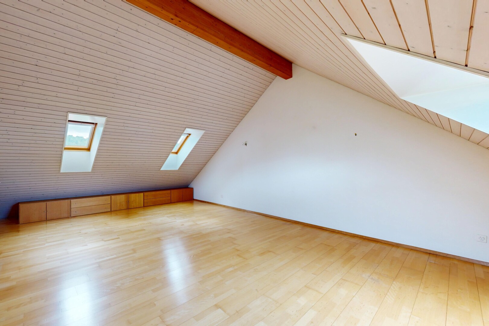 unfurnished room with beam ceiling, light wood-style flooring, and a skylight