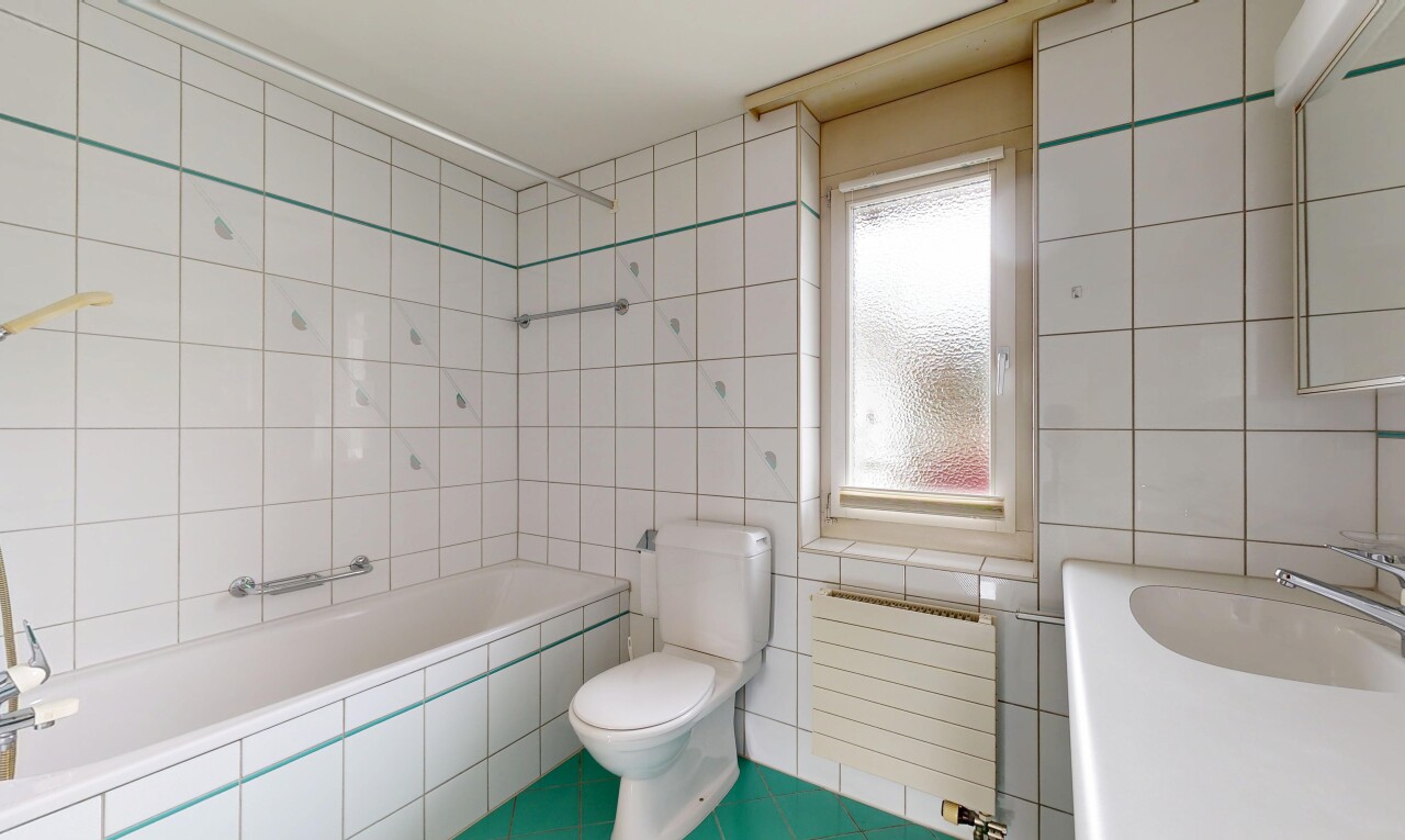 bathroom featuring tiled bath, radiator heating unit, tile walls, tile patterned flooring, and vanity
