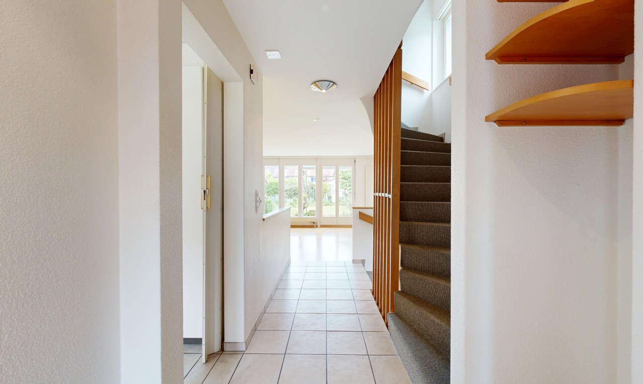 hall featuring stairway and light tile patterned floors